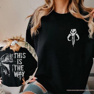 May include: Black sweatshirt with a white graphic print of a Mandalorian symbol and the text "This is the way".