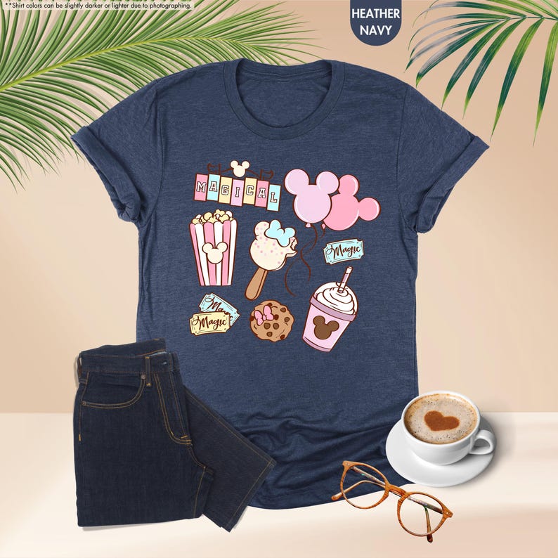 Puede incluir: Una camiseta azul marino jaspeada con un gr&aacute;fico de bocadillos con tem&aacute;tica de Mickey Mouse y el texto "Be Magical".