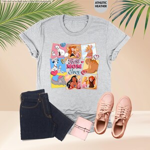 Pode incluir: Camiseta cinza com uma colagem de personagens da Disney e o texto "Best Mom Ever" em letras rosa, azul e amarelo.
