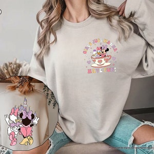 a woman wearing a sweatshirt with minnie mouse on it