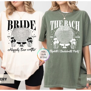 May include: Ivory and moss green t-shirts with graphic designs. The ivory shirt says "BRIDE" above a geometric sphere design, with "Happily Ever After" below. The moss green shirt says "THE BACH CLUB" with "Elizabeth's Bachelorette Party".
