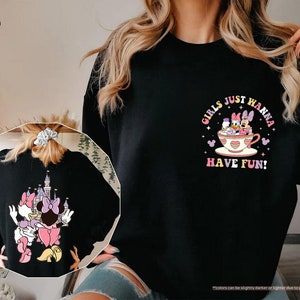 a woman wearing a black sweatshirt with a cartoon character on it