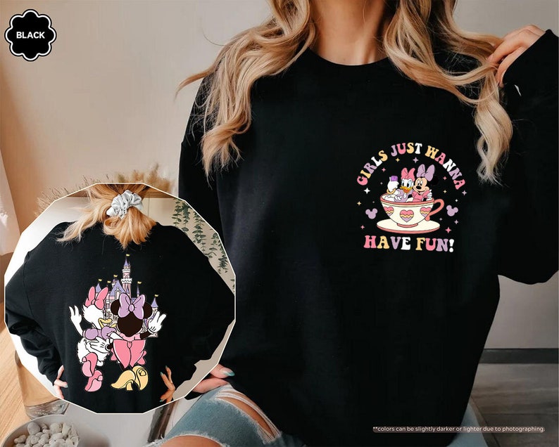 a woman wearing a black sweatshirt with a cartoon character on it