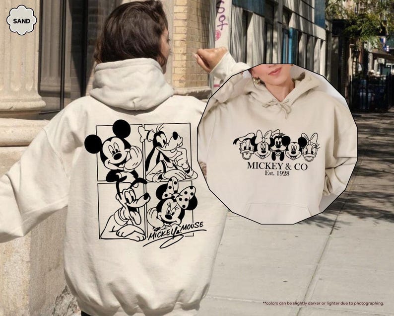 Pu&ograve; includere: Felpa con cappuccio color sabbia con grafica in bianco e nero di Topolino e amici. Il retro mostra Topolino, Pippo e Minnie, mentre il davanti presenta la scritta "Mickey & Co. Est. 1928."