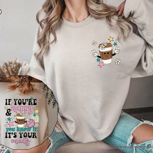 a woman wearing a sweatshirt with a cup of coffee on it