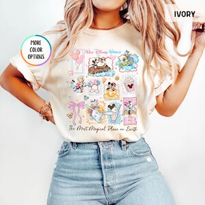 May include: Ivory-colored t-shirt featuring a colorful collage of Disney characters and attractions. The design includes Mickey and Minnie Mouse, Dumbo, and other iconic characters. Text on the shirt reads "Walt Disney World" and "The Most Magical Place on Earth."