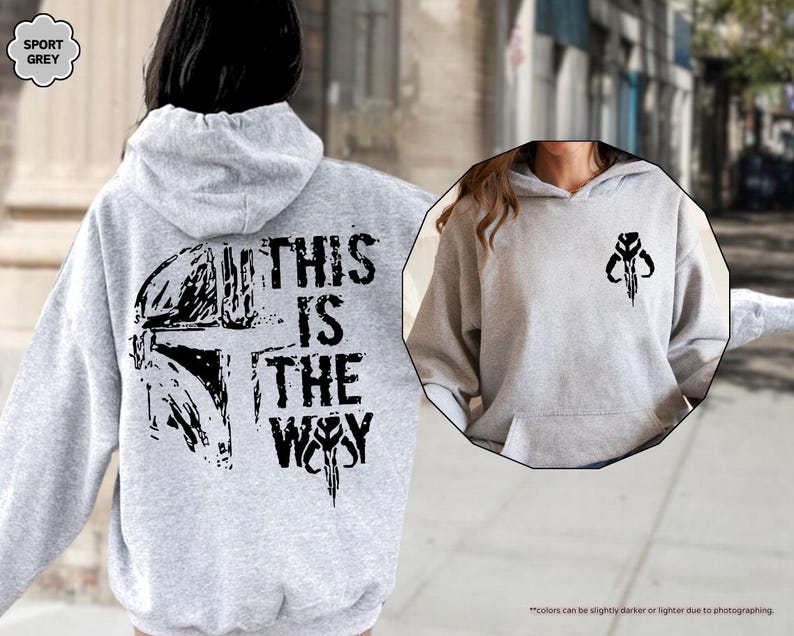 May include: A gray hooded sweatshirt with a black graphic print of a Mandalorian helmet and the text "This is the Way".