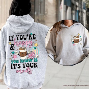 a woman wearing a gray hoodie with a cup of coffee on it