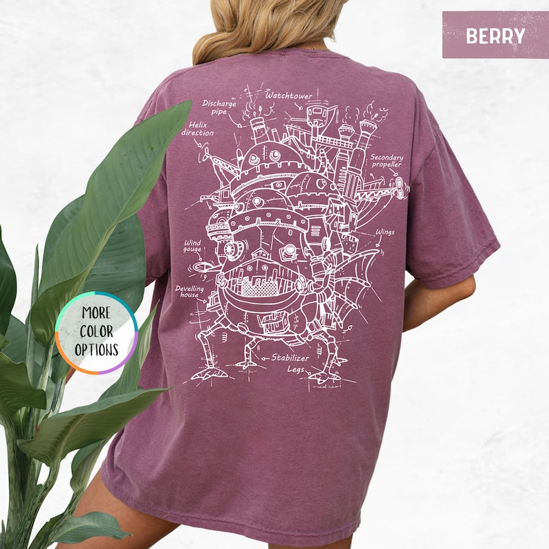 Op de afbeelding: Bessenkleurig T-shirt met een gedetailleerde witte schematische weergave van een fantastische bewegende structuur, met labels zoals "Watchtower" en "Stabilizer Legs". De tekst "MORE COLOR OPTIONS" en "BERRY" staan ook op het shirt.