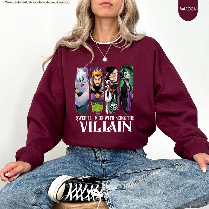 a woman sitting on a stool wearing a sweatshirt