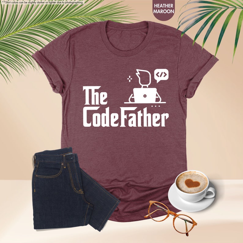 a t - shirt that says the codefather next to a cup of coffee