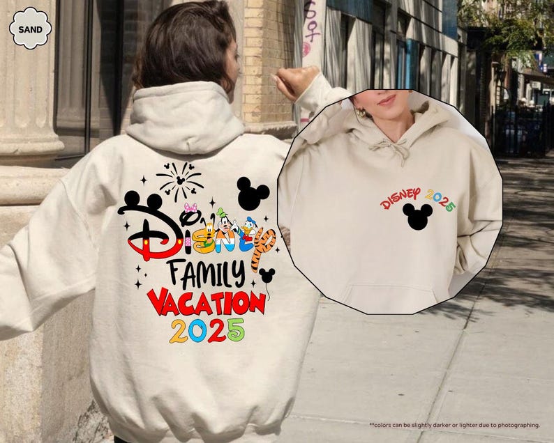 K&ouml;nnte beinhalten: Ein wei&szlig;er Hoodie mit einer schwarzen Mickey-Maus-Silhouette und dem Text "Disney 2025" auf der Vorderseite. Die R&uuml;ckseite des Hoodies zeigt eine bunte Grafik mit dem Text "Disney Family Vacation 2025".