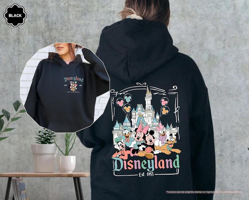 May include: Black hooded sweatshirt with a graphic print of Mickey Mouse and friends in front of the Disneyland castle. The text "Disneyland Est. 1955" is printed below the graphic.