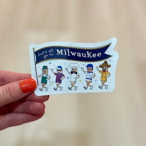 May include: A sticker featuring five cartoon figures in various outfits, each with a different hat. The sticker has a banner that reads "Let's all go to Milwaukee" in blue and white. The figures are walking and waving.