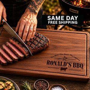May include: A wooden cutting board with a carved border, featuring the text "RONALD'S BBQ" and a cow graphic. A grilled steak is being sliced on the board. The text "SAME DAY FREE SHIPPING" is also visible.