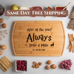 May include: A brown bamboo cutting board with a black engraved design. The design includes the text "After all this time? Always" with the names "Drake & Millie" and the date "Est. 06.05.1980".