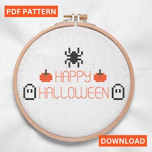 May include: A cross-stitch design in a wooden embroidery hoop. The design features a black spider, two orange pumpkins, and the words "HAPPY HALLOWEEN" in orange. Two pixelated ghosts flank the text. The words "PDF PATTERN" and "DOWNLOAD" are in orange boxes.