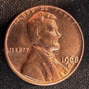 Op de afbeelding: Een koperkleurige Amerikaanse munt uit 1968. De voorzijde toont een profiel van Abraham Lincoln, het woord "LIBERTY" en de inscriptie "IN GOD WE TRUST". Het jaartal "1968" en het muntteken "S" zijn ook zichtbaar.