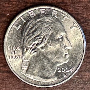 May include: A white ceramic mug with a black handle and the text "But First, Coffee" in a black, bold font. The mug is on a white surface. The mug is approximately 4 inches tall.