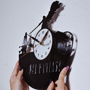 May include: Black vinyl record clock with a Final Fantasy theme. The clock face is white with black numerals and hands. The design incorporates character silhouettes and the text "FINAL FANTASY".