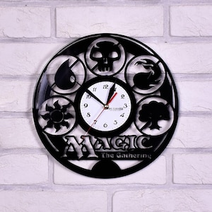 May include: Black vinyl record clock featuring the Magic: The Gathering logo and five symbols representing the five colors of mana: white, blue, black, red, and green.