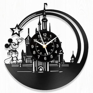 May include: Black vinyl record clock featuring a silhouette of Mickey Mouse and the Disney castle. The clock face is black with white numbers and hands. The clock is surrounded by a black frame with a white star.