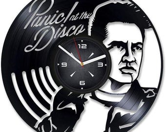 May include: Black vinyl record clock featuring a silhouette of the lead singer from the band Panic! At The Disco. The clock face is black with white numbers and hands.
