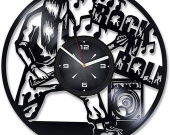 Könnte beinhalten: Schwarze Schallplattenuhr mit einer Silhouette eines Rock'n'Roll-Musikers, der Gitarre spielt, mit den Worten "Rock N Roll" und Noten. Das Zifferblatt der Uhr ist schwarz mit weißen Zahlen und Zeigern.