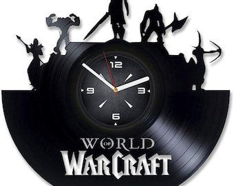 Puede incluir: Reloj de vinilo negro con siluetas de personajes de World of Warcraft. La esfera del reloj es negra con números y manecillas blancas. Las palabras "WORLD OF WARCRAFT" se muestran en blanco debajo.