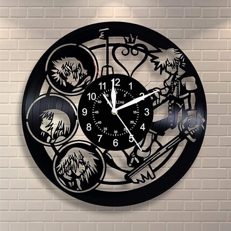 May include: Black vinyl record clock featuring a stylized image of a character from the Kingdom Hearts video game series. The clock face is a circular design with Roman numerals and a silver hand.