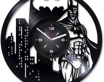 Könnte beinhalten: Schwarze Schallplattenuhr mit einer Silhouette von Batman, einer Stadtlandschaft und einem Zifferblatt mit römischen Ziffern.