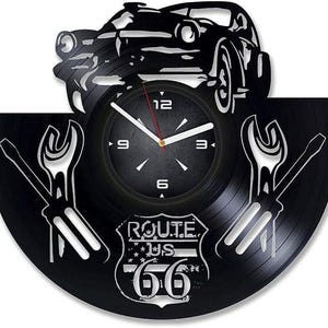 Könnte beinhalten: Schwarze Schallplattenuhr mit Route 66-Design, mit einer Silhouette eines Oldtimers, Grafiken von Schraubenschlüssel und Schraubendreher sowie einem Zifferblatt mit römischen Ziffern.