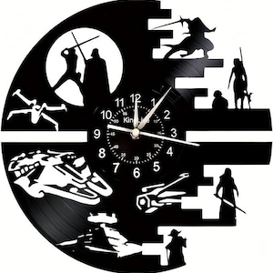 May include: Black vinyl record clock featuring a silhouette of the Death Star from Star Wars. The clock face is a white clock with black numbers and hands. The clock is surrounded by various Star Wars characters and symbols.