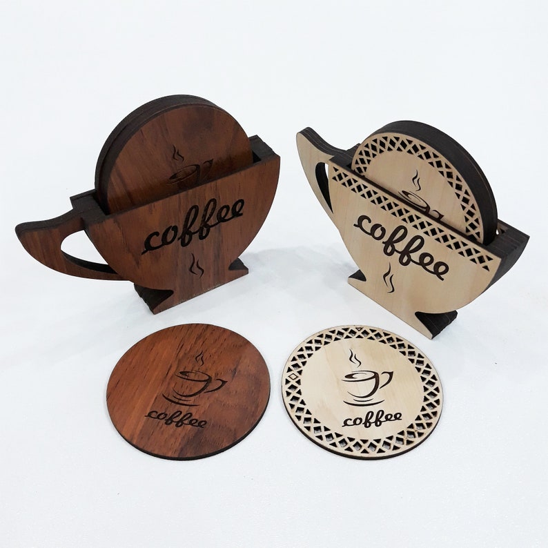 May include: Set of six wooden coasters with a coffee cup design. The coasters are in two different colors, brown and natural wood. The coasters are stacked in a cup shape, with the word "coffee" engraved on the side.