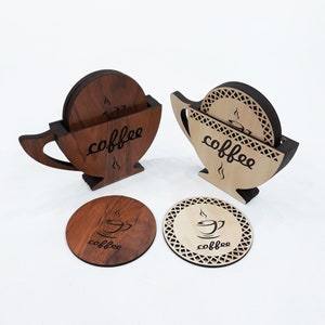 May include: Set of six wooden coasters with a coffee cup design. The coasters are in the shape of a coffee cup and have a brown and natural wood finish. The coasters are stacked in two sets of three, with the top coaster in each set showing the coffee cup design.