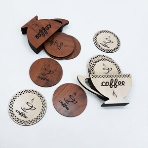 May include: Set of six wooden coasters with a coffee cup design. The coasters are in two styles: one with a brown wood finish and the other with a light wood finish. The coasters are arranged in a circle around a wooden coffee pot.