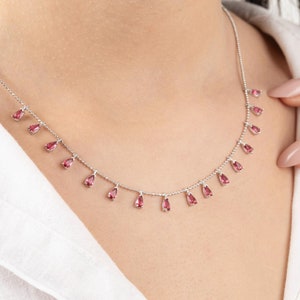 Collar con lágrima de rubí en oro de 14 k y cadena de plata de ley.