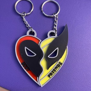 May include: A pair of silver keychains with a heart-shaped charm. The charm is split in half, with one side red and yellow and the other side yellow and orange. The words "Best" and "Friends" are written on the charm.