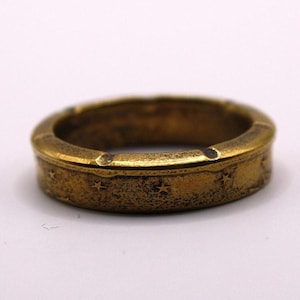 May include: A gold-toned ring with a textured surface and a band of stars around the edge.