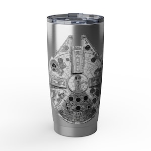 Może przedstawiać: Stalowy kubek podróżny ze szczegółową czarno-białą ilustracją statku kosmicznego Millennium Falcon. Kubek ma srebrną pokrywkę i cylindryczny korpus, idealny do gorących lub zimnych napojów.
