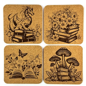 May include: A set of four square cork coasters featuring dark brown laser-engraved illustrations. The designs include a dragon perched on books, a bouquet of flowers on books, an open book with flowers and butterflies, and mushrooms on books.