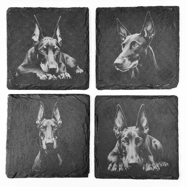 May include: Set of four square slate coasters, each featuring a detailed black and white portrait of a Doberman Pinscher. The dog portraits vary in pose and angle, creating a cohesive set for home decor.
