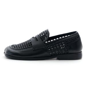 May include: Black leather loafer with woven detailing on the vamp and sides. The shoe features a classic penny loafer design with a low heel and a smooth, solid sole. A stylish and comfortable footwear option.