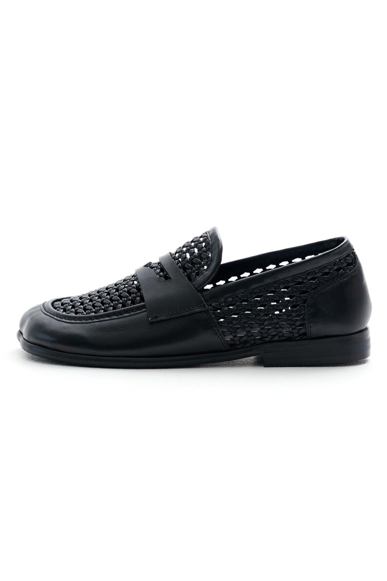 May include: Black leather loafer with woven detailing on the vamp and sides. The shoe features a classic penny loafer design with a low heel and a smooth, solid sole. A stylish and comfortable footwear option.