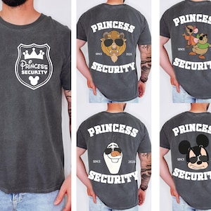 Może przedstawiać: Ciemnoszare koszulki z białymi grafikami. Jedna koszulka przedstawia tarczę z napisem "Princess Security" i głową Myszki Miki. Inne koszulki przedstawiają postacie Disneya z napisem "Princess Security" i "Since 2026".