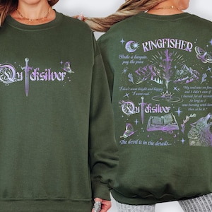 K&ouml;nnte beinhalten: Ein olivgr&uuml;nes Sweatshirt mit dem Wort "Quicksilver" in einer stilisierten Schriftart auf der Vorderseite, mit einem Schwertdesign. Auf der R&uuml;ckseite befindet sich das Wort "Kingfisher" und ein grafisches Design mit einem Wolf, Bergen und Text.