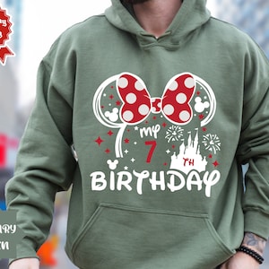 May include: Green hooded sweatshirt with a white graphic of Minnie Mouse ears, a bow, a castle, fireworks, and the text "My 7th Birthday".