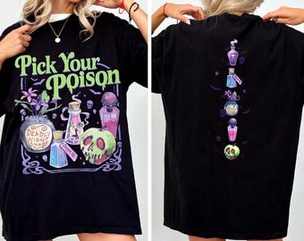 Può includere: Una t-shirt nera con una stampa grafica che riporta il testo Pick Your Poison in verde. Il design frontale include fiori viola, boccette di pozioni e una mela verde a forma di teschio. Il retro presenta una disposizione verticale delle stesse icone.