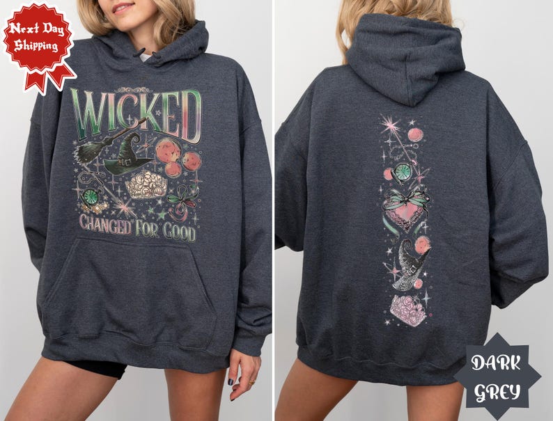 May include: Dark grey hooded sweatshirt with a graphic print of a witch's hat, stars, and the text "Wicked Changed For Good". The back of the sweatshirt has a vertical graphic print of a heart, stars, and a bird.