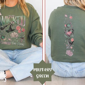 May include: A green sweatshirt with a graphic print of a witch, a crown, and the words "Wicked Changed For Good".